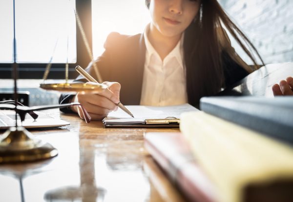 Close up lawyer businessman working or reading lawbook in office workplace for consultant lawyer concept.